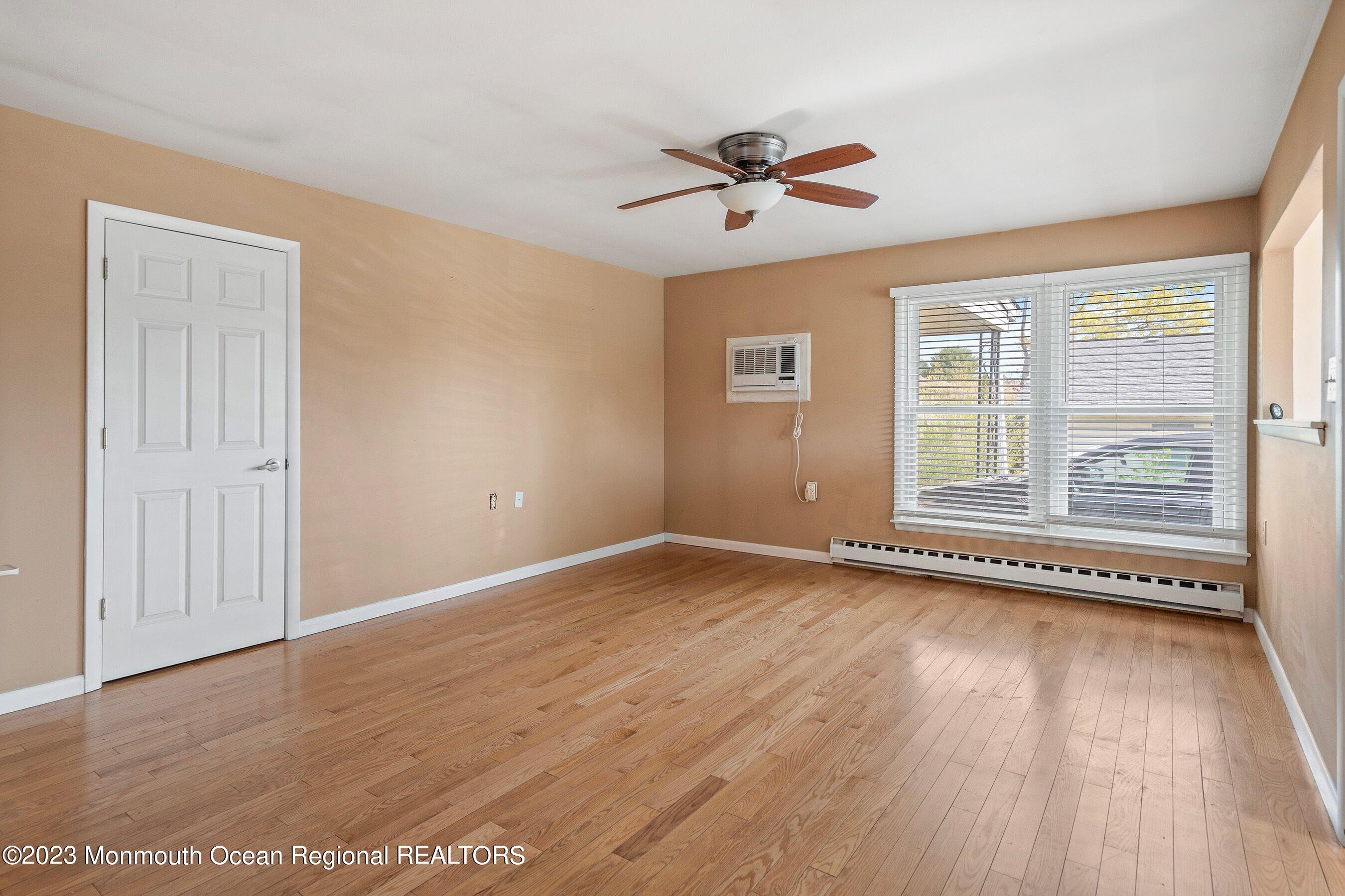 16 B Magnolia Road, Unit 1A Manahawkin, NJ 08050 - Photo 9 of 21 a view of an empty room with a window and wooden floor