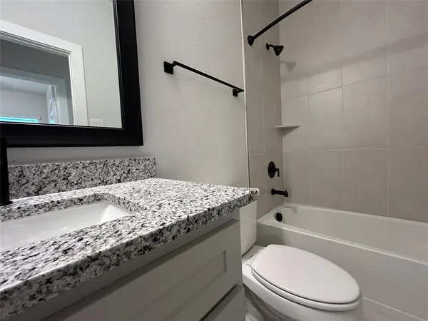 an empty room with a chandelier fan and windows