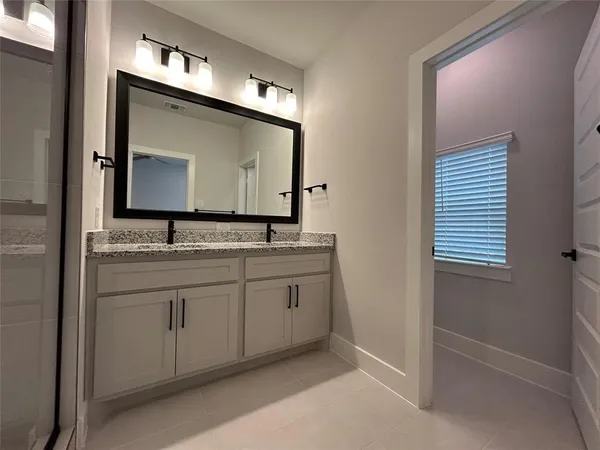 a bathroom with a granite countertop sink toilet a mirror and shower
