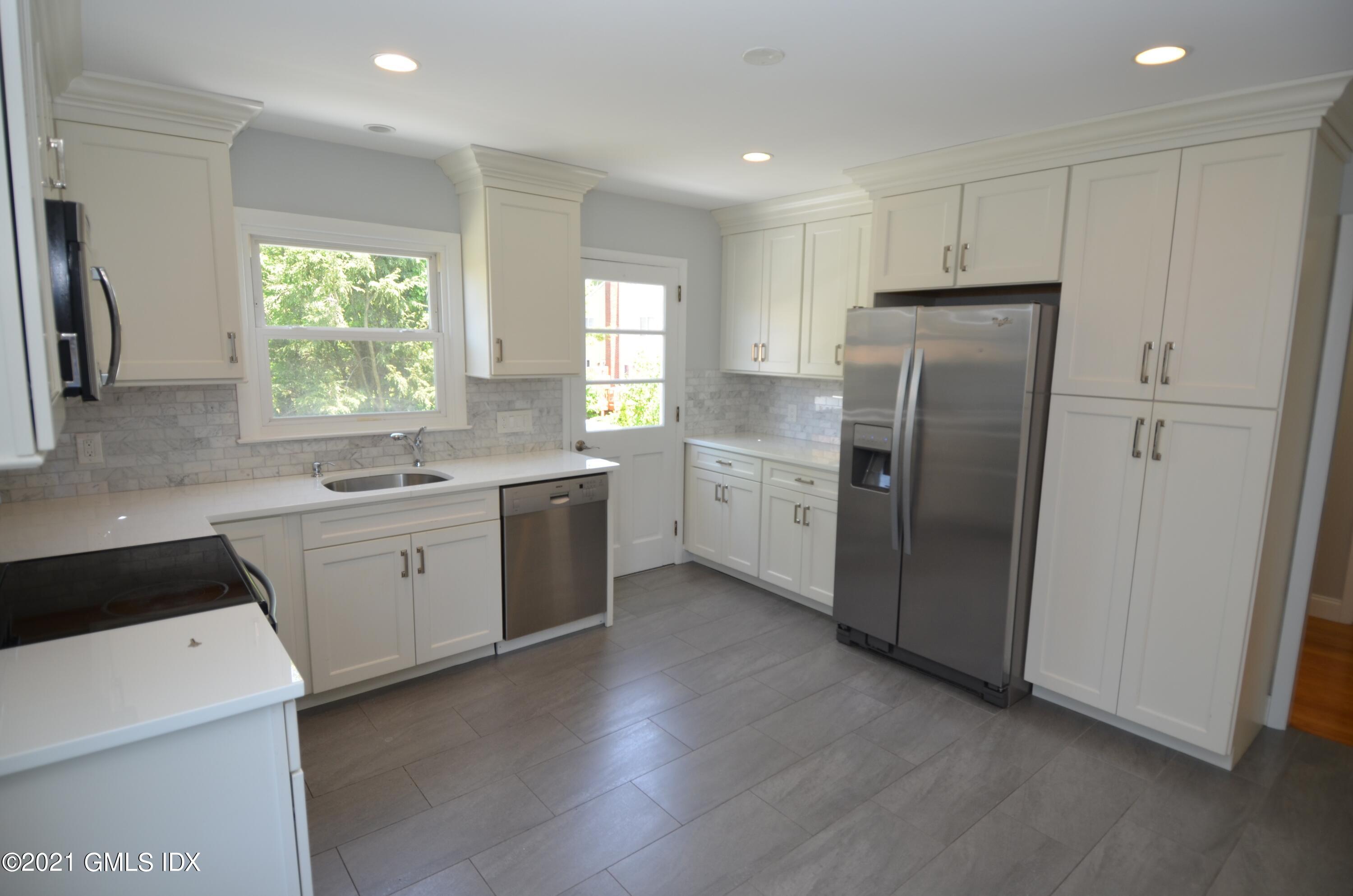 5 Ridge Place, Unit 1 Greenwich, CT 06831 - Photo 9 of 29 a kitchen with white cabinets and white appliances