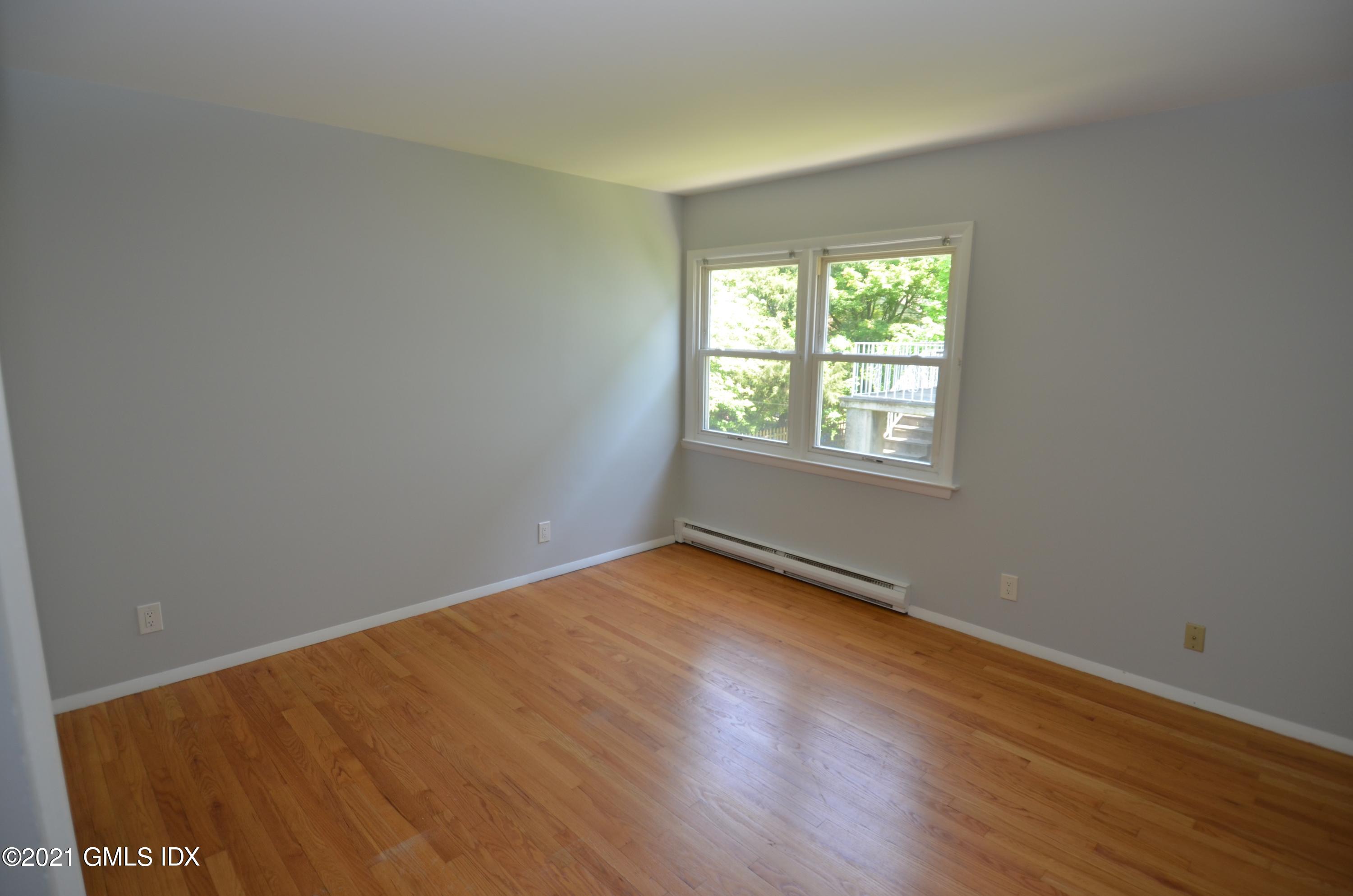 5 Ridge Place, Unit 1 Greenwich, CT 06831 - Photo 10 of 29 a view of an empty room with wooden floor and a window