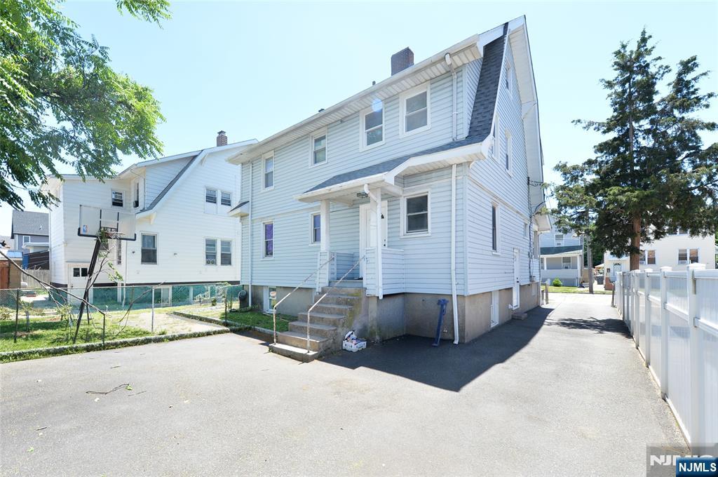 62 Broadway, Unit 1 Hackensack, NJ 07601 - Photo 2 of 25 a view of a white house with a yard and garage