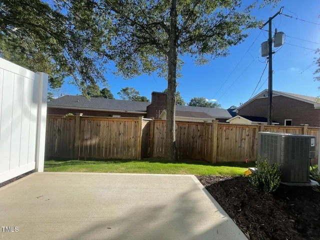 a view of backyard with potted plants and a large tree