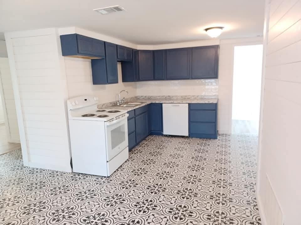 1309 South 5th Street Bonham, TX 75418 - Photo 2 of 8 a kitchen with granite countertop a stove a sink and a refrigerator