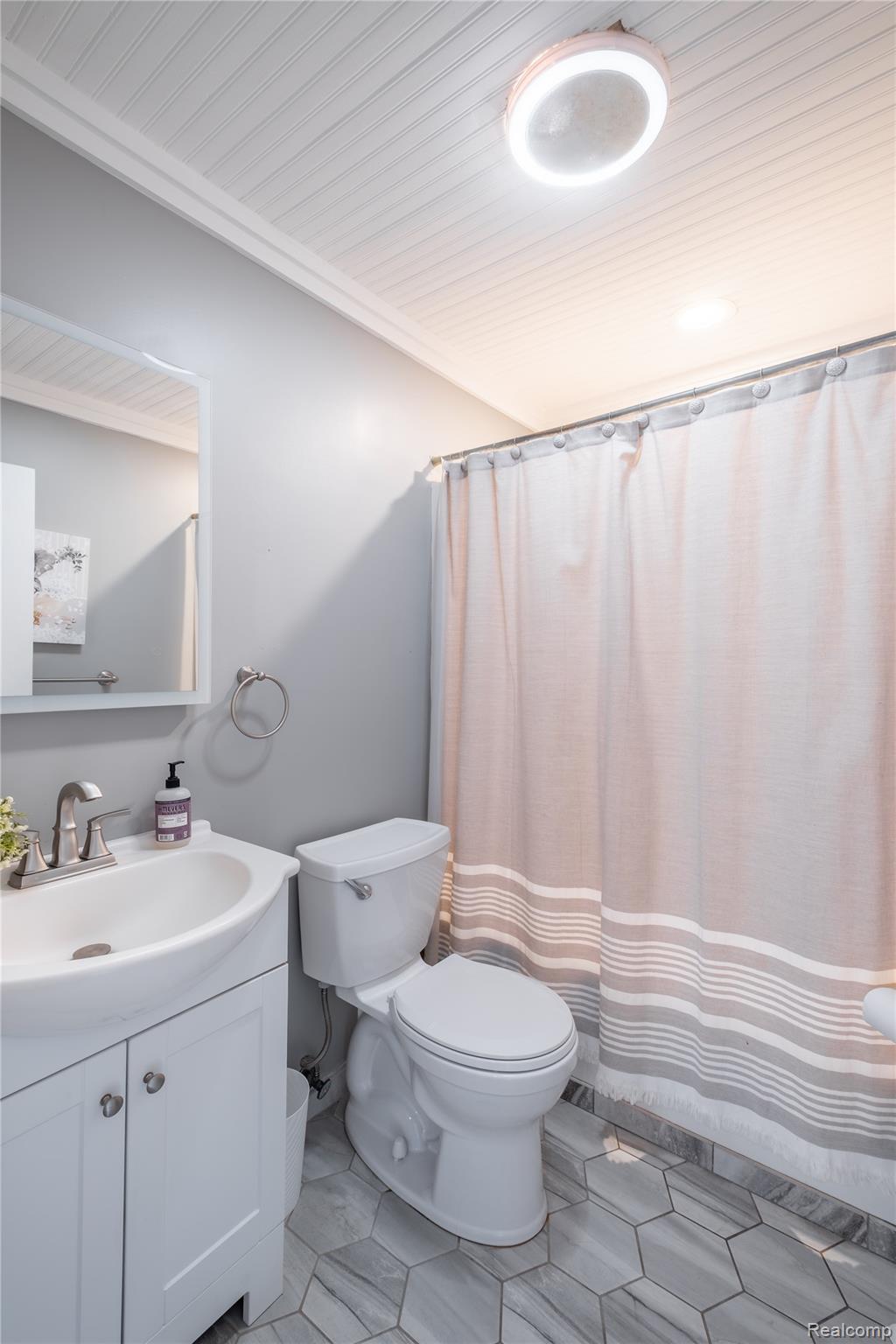 10250 Duffield Road Gaines, MI 48436 - Photo 17 of 28 Hexagonal tile flooring, beadboard ceiling, recessed lighting, white vanity with integrated sink, and brushed nickel fixtures