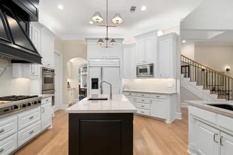 a kitchen with stove cabinets and stainless steel appliances