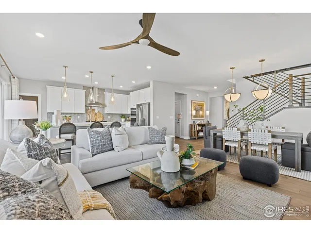 a living room with furniture a chandelier and a dining table