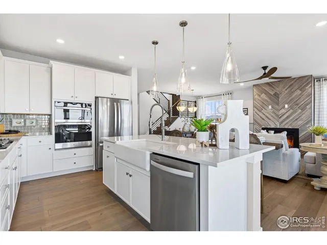 a living room with furniture kitchen view and a chandelier