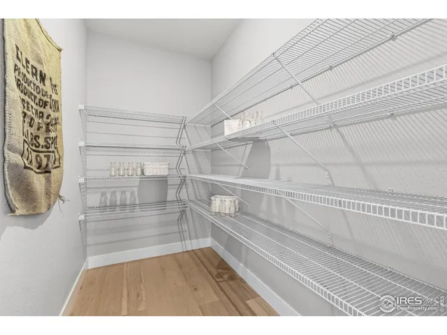 a large kitchen with stainless steel appliances kitchen island granite countertop a stove a sink dishwasher and white cabinets with wooden floor