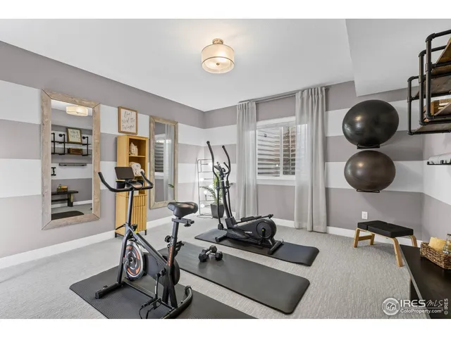 a living room with stainless steel appliances couches and a dining table with rug