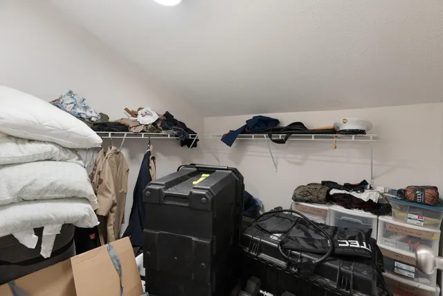 a view of walk in closet with clothes and shoes