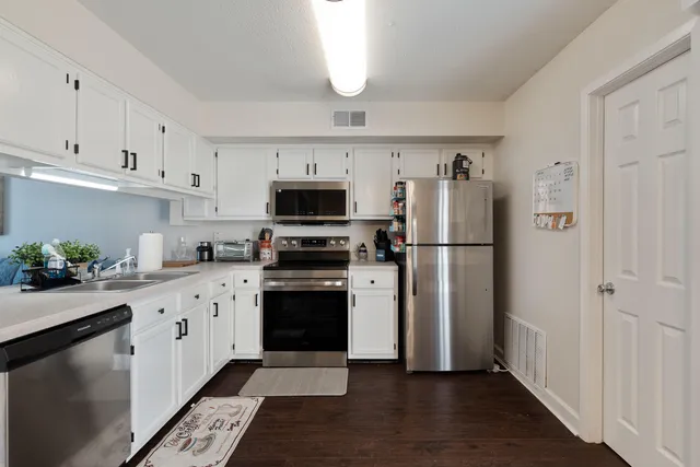 a kitchen with cabinets stainless steel appliances and a window