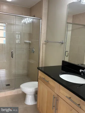 a bathroom with a granite countertop sink toilet and shower