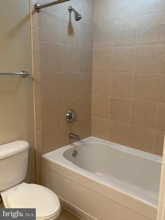 a white toilet sitting next to a bath tub