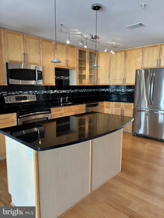 a kitchen with stainless steel appliances granite countertop a sink a stove and a refrigerator