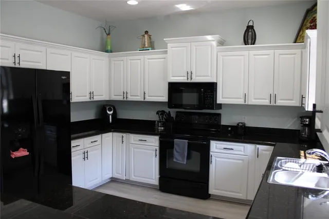 a kitchen with a sink a stove and cabinets