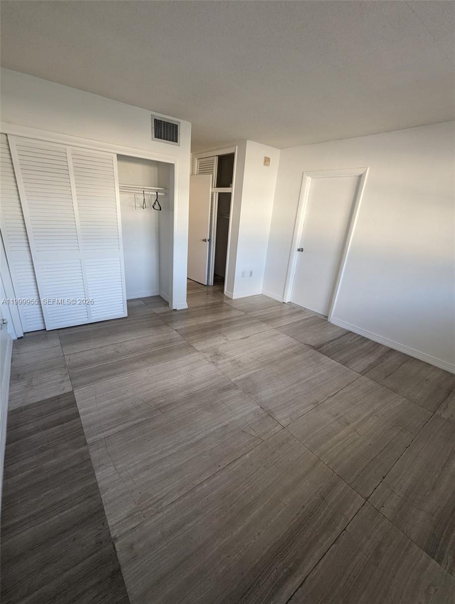7360 Southwest 82nd Street, Unit E202 Miami, FL 33143 - Photo 6 of 11 a view of an empty room with wooden floor