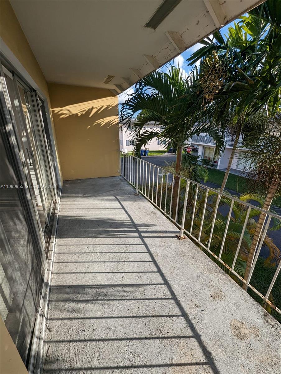 7360 Southwest 82nd Street, Unit E202 Miami, FL 33143 - Photo 10 of 11 a view of balcony with wooden floor and seating space