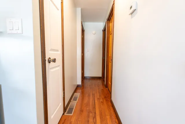 a view of a hallway with wooden floor