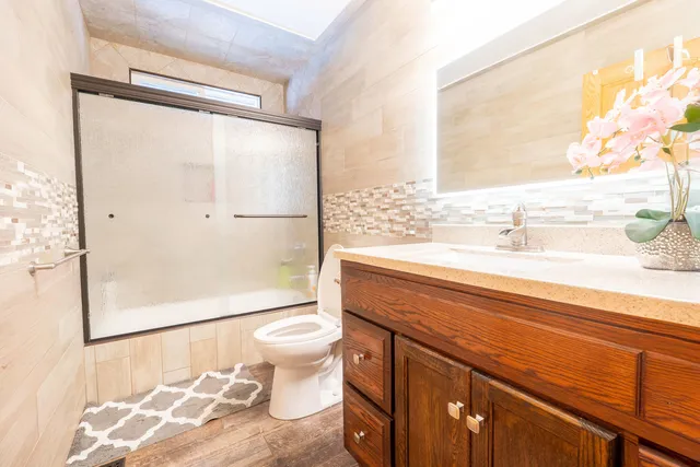 a bathroom with a granite countertop sink toilet and shower