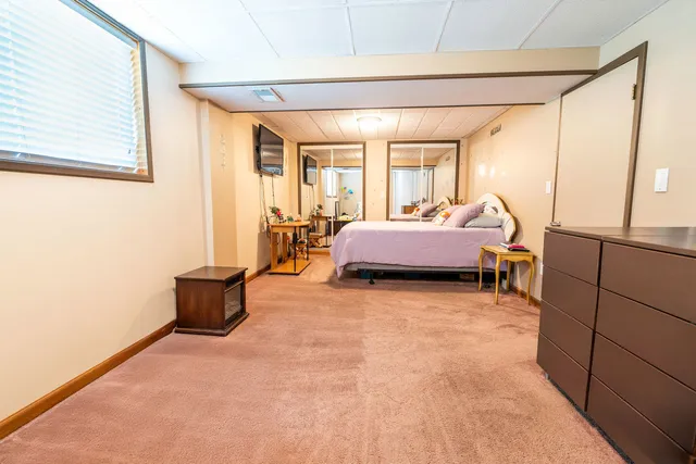 a room with a bed and a dresser next to a window