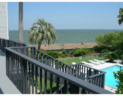 a view of a balcony with wooden floor and fence