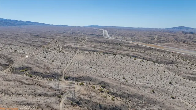a view of a dry yard with mountains in the background
