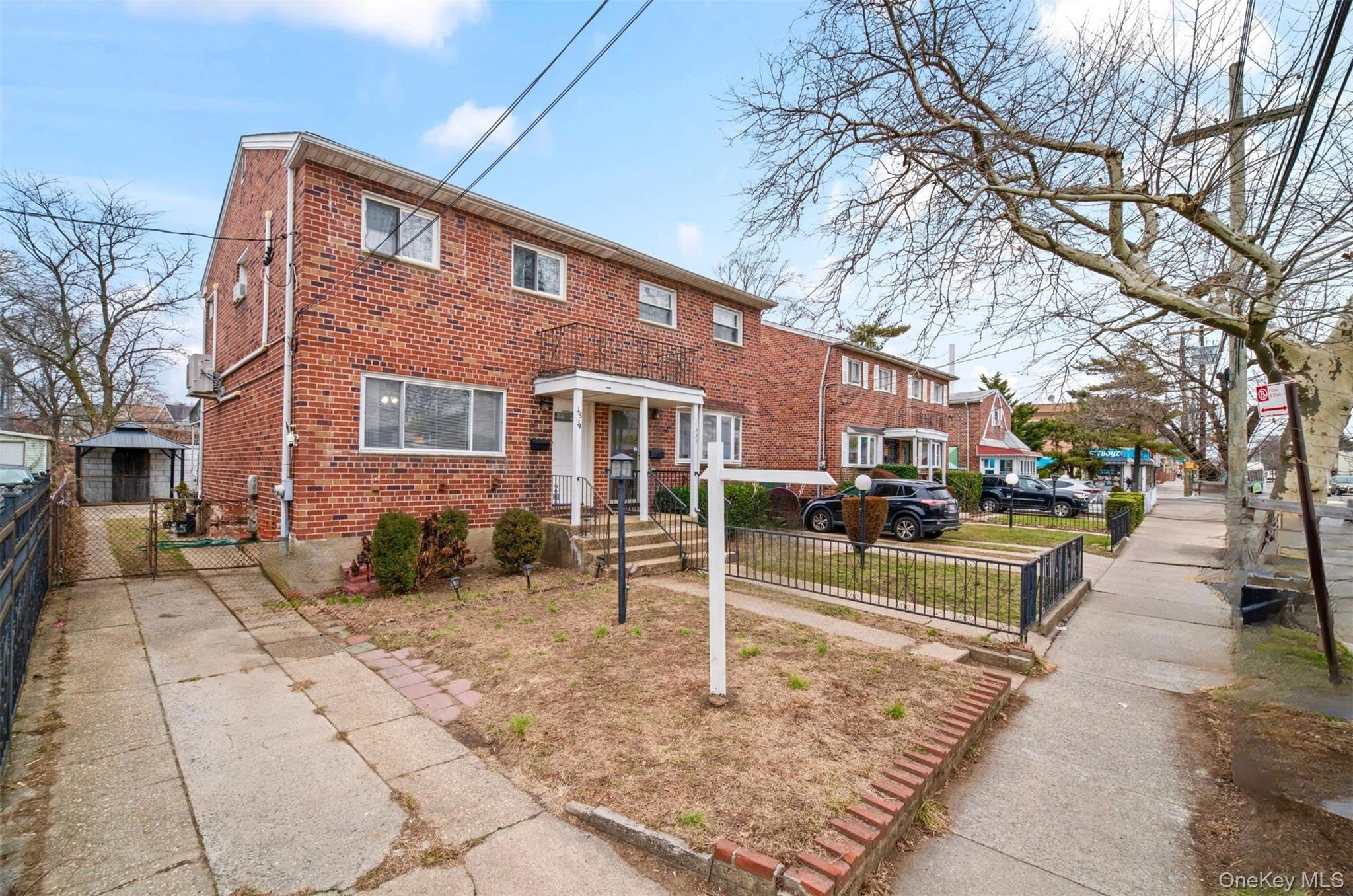 113-34 Springfield Boulevard Queens, NY 11429 - Photo 21 of 26 a view of a brick building next to a yard
