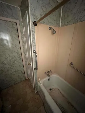 a bathroom with a tub a sink and shower