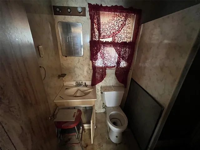 a bathroom with a toilet sink and mirror