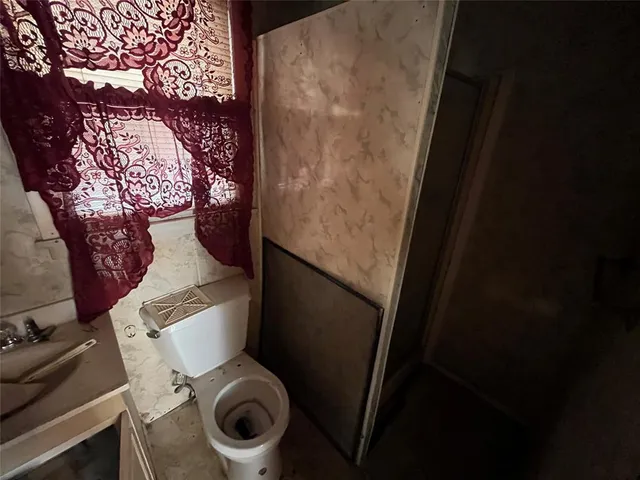 a toilet sitting in a bathroom next to a sink