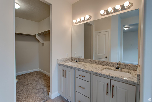 1512 West 600 North, Unit O4A Mapleton, UT 84664 - Photo 13 of 24 Bathroom with a spacious closet, double vanity, light colored carpet, and a textured ceiling