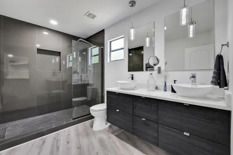 a bathroom with a double vanity sink toilet and shower