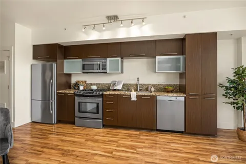 a kitchen with stainless steel appliances granite countertop a refrigerator and a stove
