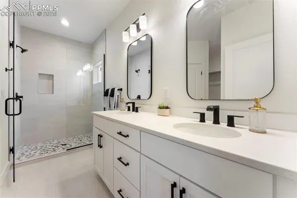 a bathroom with a double vanity sink mirror double and shower