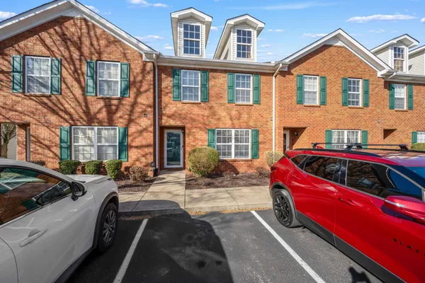 a front view of a house with cars