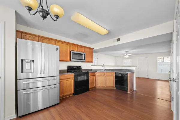 a kitchen with granite countertop stainless steel appliances and wooden floor