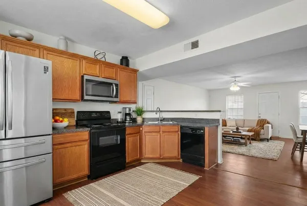 a kitchen with granite countertop a stove top oven and refrigerator