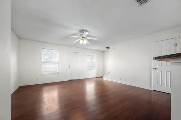 an empty room with wooden floor and window