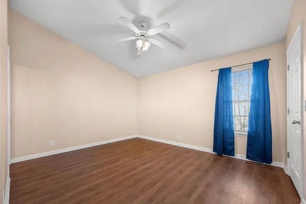 a view of an empty room with wooden floor