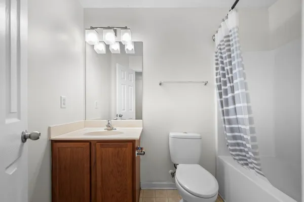 a bathroom with a sink a toilet a mirror and shower curtain