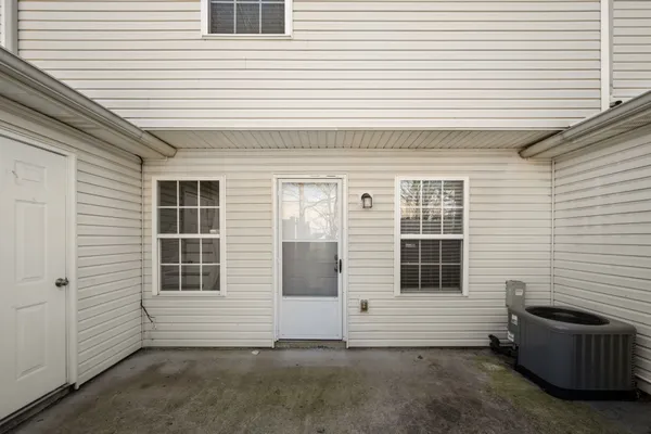 a view of a patio with couple of chairs and a potted plant