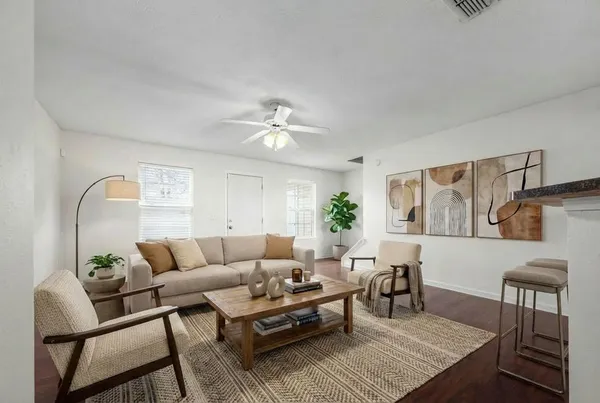 a living room with furniture and wooden floor