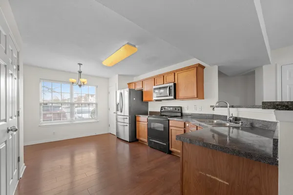 a kitchen with stainless steel appliances granite countertop a sink stove and cabinets
