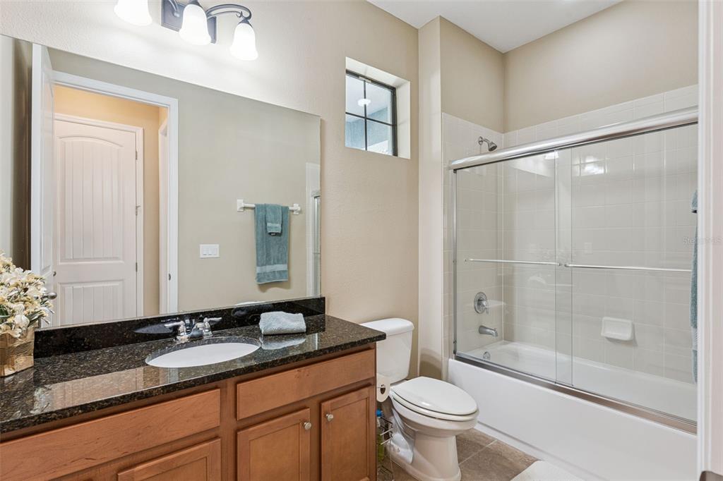13232 Longacre Drive Windermere, FL 34786 - Photo 13 of 28 a bathroom with a granite countertop sink a toilet and shower