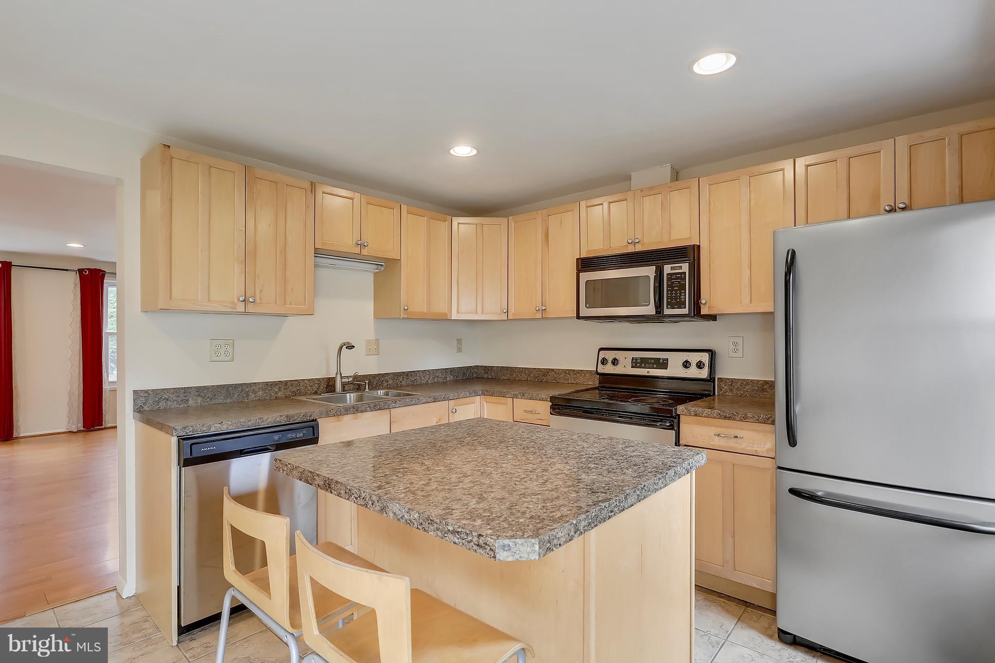 10740 Lester Street Silver Spring, MD 20902 - Photo 3 of 30 a kitchen with granite countertop a refrigerator stove and microwave