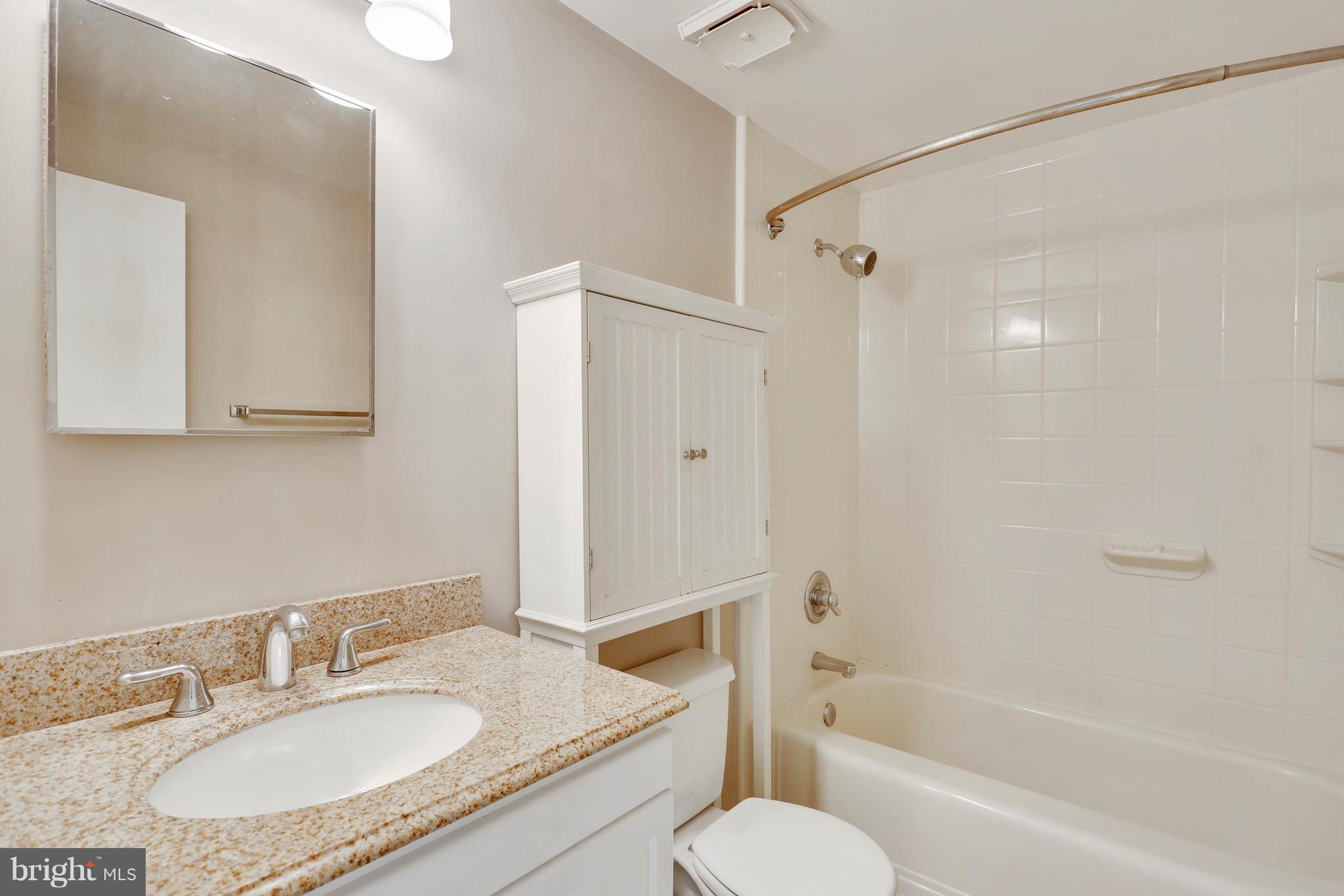10740 Lester Street Silver Spring, MD 20902 - Photo 23 of 30 a bathroom with a granite countertop sink toilet and shower