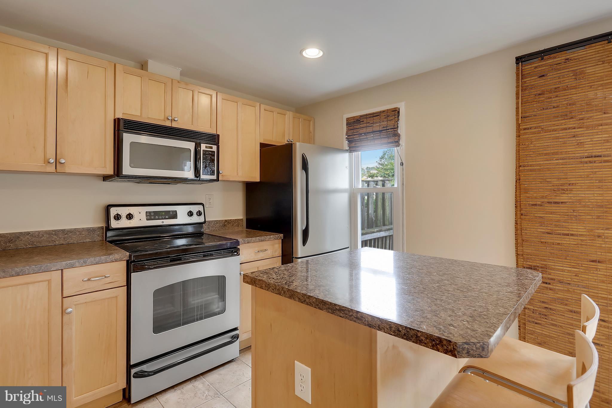 10740 Lester Street Silver Spring, MD 20902 - Photo 4 of 30 a kitchen with granite countertop a stove microwave and refrigerator