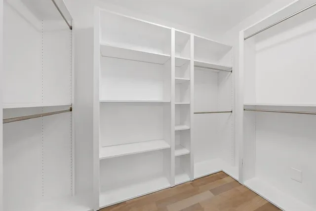 a view of walk in closet with empty racks