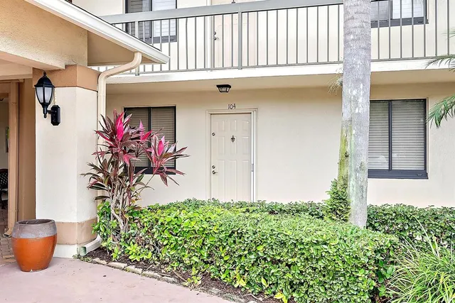 a front view of a house with plants
